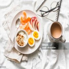 Morning inspiration and planning. Healthy breakfast - yogurt with granola, fresh fruit apples, tangerines and coffee with milk on a light background, top view